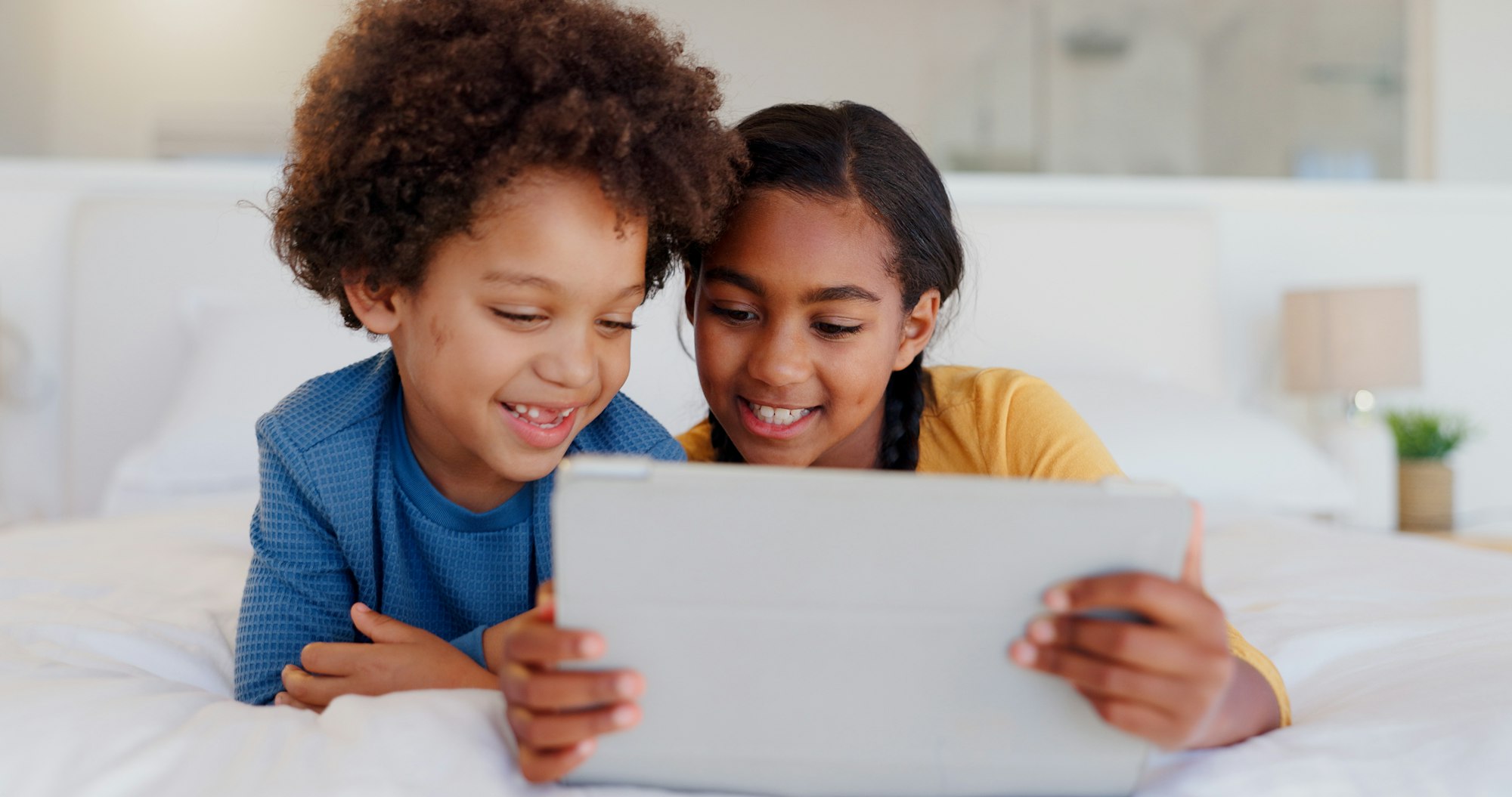 Happy children, tablet and bed for streaming entertainment, morning or holiday weekend together at